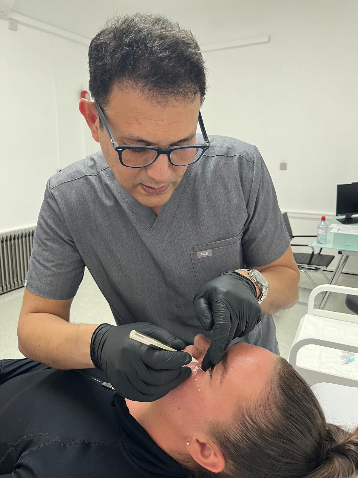 dr sna doing marking with white marker on women face